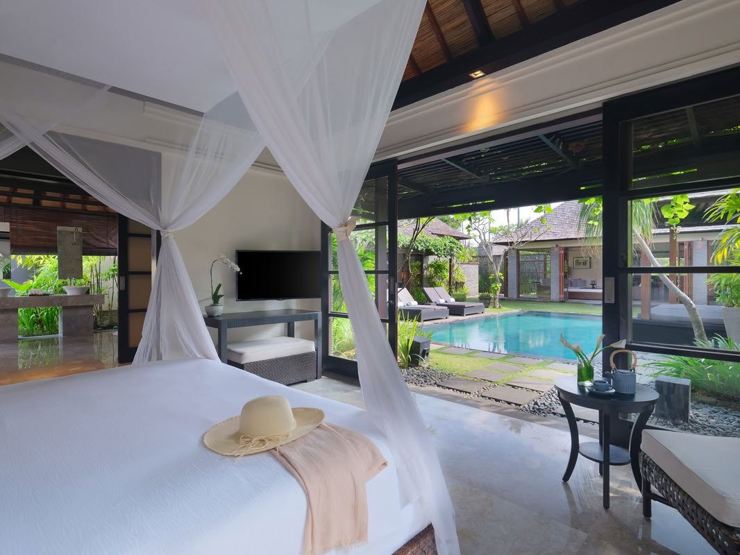 A bedroom opening onto a private pool at Peppers Seminyak